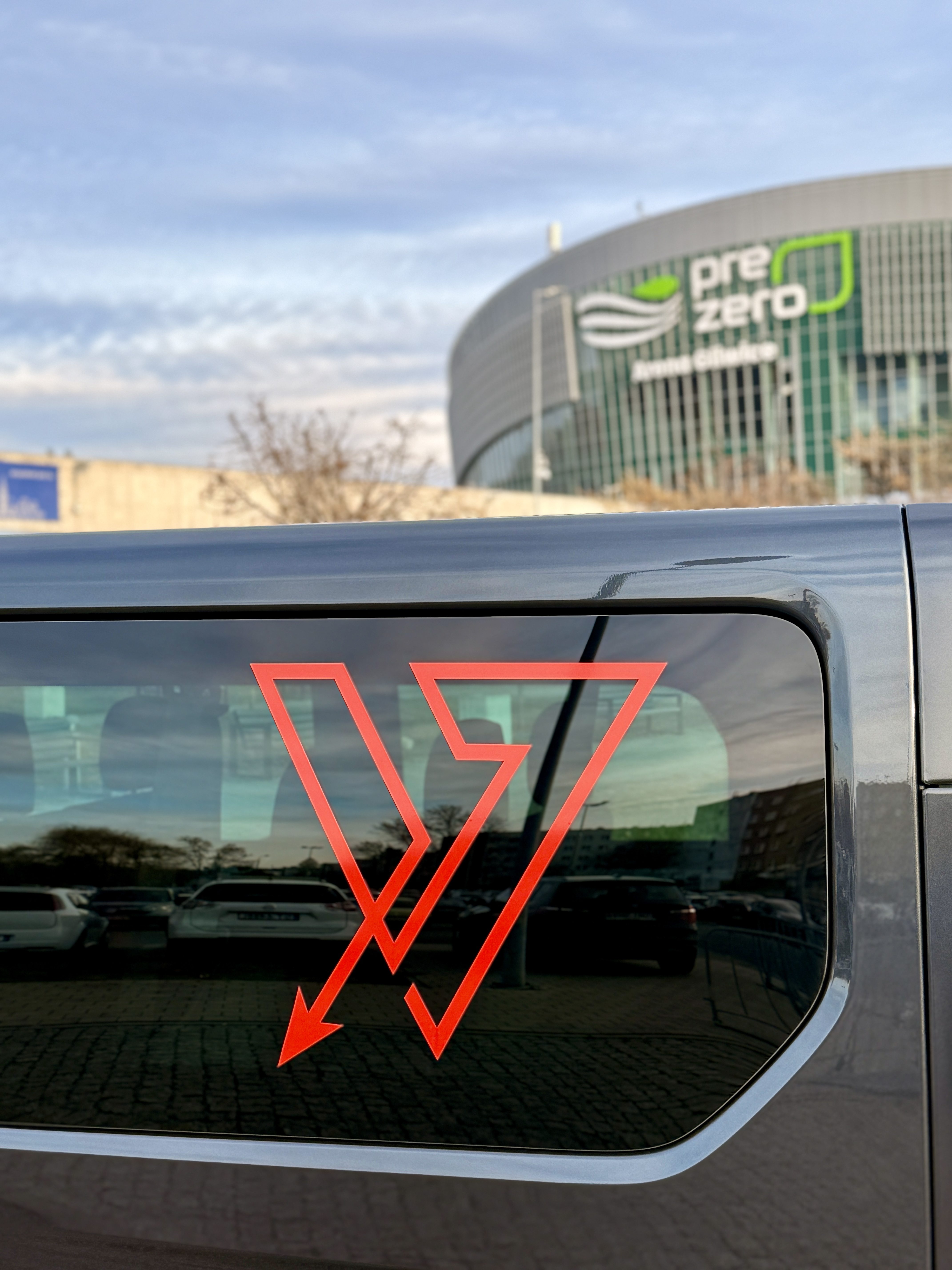 Logo Via Viator na karoserii Renault Trafic — zbliżenie na literę V.